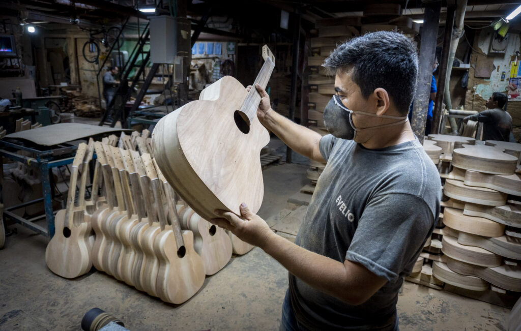 Artesano luthier fabricando una guitarra artesanal de madera, hecha a mano con técnicas tradicionales.